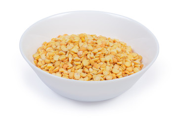 Yellow split peas in bowl close-up on white background