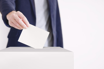 Voting. Man putting a ballot into a voting box.