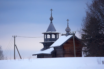 wooden church in the forest winter / landscape christian church in the winter landscape, view of the wooden architecture in the north