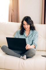 Fototapeta premium Bbeautiful woman using laptop computer at home on sofa