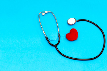 Stethoscope, red heart and cardiogram on table. Cardiology concept