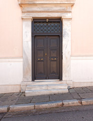 Obraz na płótnie Canvas classical house entrance brown wooden door, Athens downtown, Greece