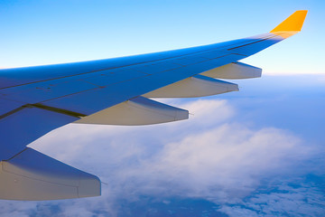 wing airplane view of sky / blue sky and wing of an airplane, view from the cabin of an airplane, concept of air transport