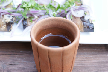 chacha in a glass. handmade clay glass with chacha on the background of a snack