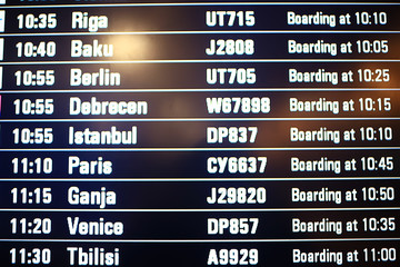 Obraz premium board airport departures schedule / departure of city airplanes flights font at the airport