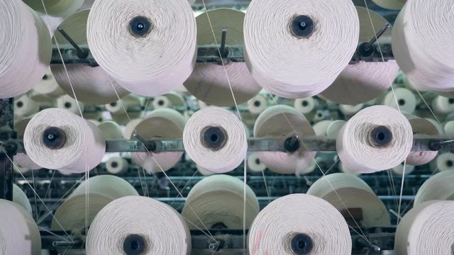Spinning clews with threads on a rack at a textile plant.