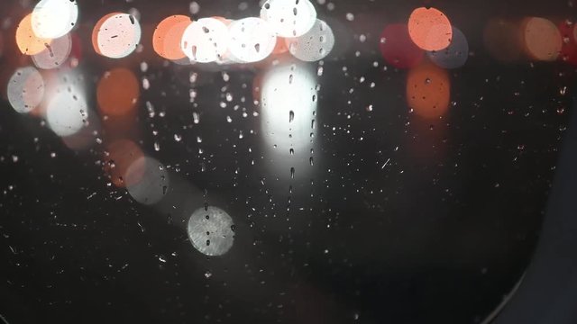 Rain at night on an airplane window.  Drops come streaming down like tears