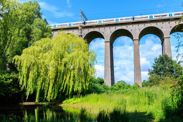 Fototapeta na wymiar Digswell Viaduct (Welwyn Viaduct) with train in motion, located between Welwyn Garden City and Digswell in the UK