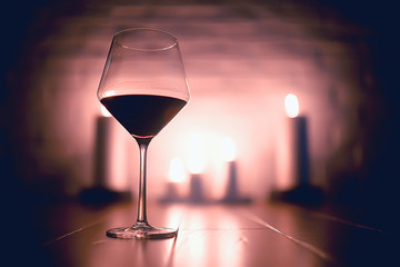 red wine glass serving / romantic dinner in the interior of the restaurant, a table served with a glass of grapes wine