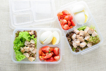 Modern style clean food, boiled egg, grilled chicken and avocado, strawberry, vegetable salad.