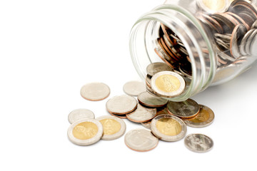 New Thai Baht coins spilling from a glass jar, isolated on white background. Business and finance...