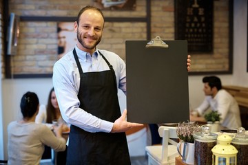 Happy waiter with blackboard
