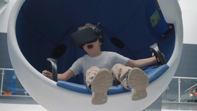 Boy in a virtual reality headset in a moving interactive chair
