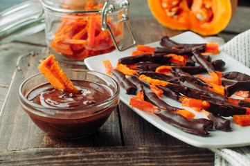 Homemade candied pumpkin slices covered with melted chocolate