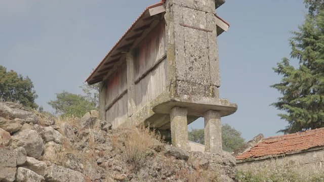 Low angle revealing a granary called espigueiro in a rural village on a hill Friaes Tras-os-Montes Portugal