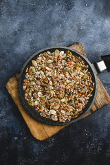 close up of pumpkin and sunflower seeds roasted in black pan, top view