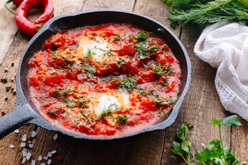 Egg with tomato sauce and vegetables in a skillet. Breakfast. Homemade. Shakshuk.
