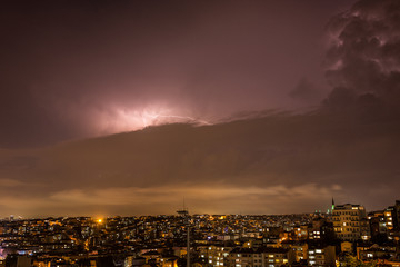 Lightning storm over city in purple light