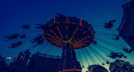 spinning amusement park ride at sunset in vienna 