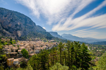 Fototapeta na wymiar Vue panoramique sur le village Moustiers-Sainte-Marie, Provence, France. Printemps, ciel bleu avec de beaux nuages. 