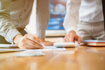 man holding pen to point in paperwork, meeting concept