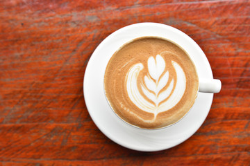 Coffee cup with latte art foam on wood table in coffee shop with copy space.Coffee is one of the most popular beverages.Improve Energy Levels and Burn Fat