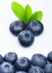 Fresh raw organic blueberries with leaf on white background. Macro close up