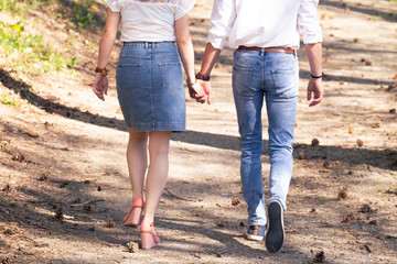 Couple marchant main dans la main en amoureux en forêt