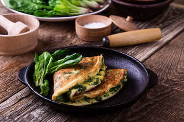 Spinach omelette in cast iron skillet, healthy vegetarian breakfast