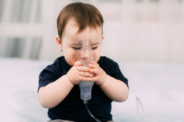 a little girl yourself holding the mask of the nebulizer, making inhalation