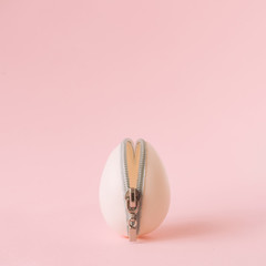 Easter egg with zipper on pastel pink background. Creative minimal concept.