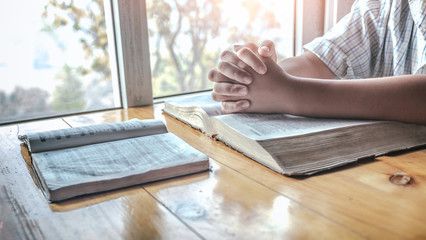 Christian boy praying on holy bible. christian concept.
