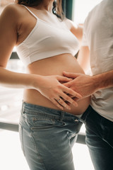 A man touches of the belly of his pregnant wife.