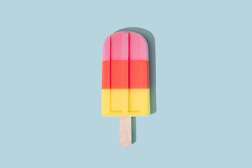 Colorful Ice cream popsicle on pastel blue background. Minimal summer concept. Flat lay.