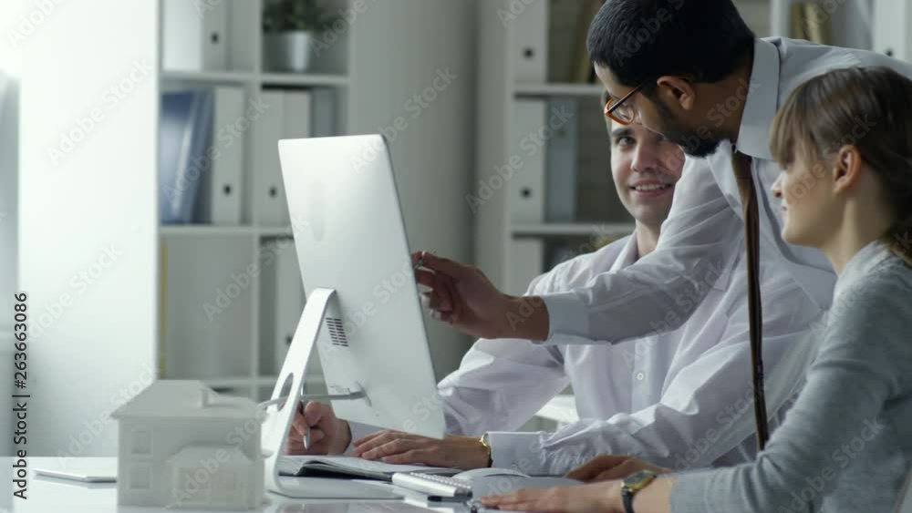 Aufkleber tracking shot of group of professional architects pointing at computer screen and discussing project