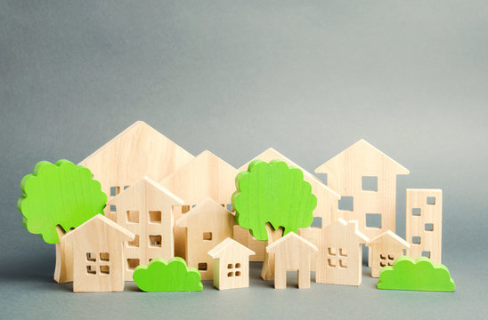 Miniature wooden toy houses and trees. Real estate concept. Architecture in the city. Infrastructure. Affordable housing. Construction of new buildings. City greening. Renovations and recovery