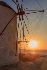  The symbol of Mykonos: seascape at sunset with white famous windmills, Cyclades, Greece.	