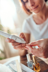 Woman filings nails with electric nail file