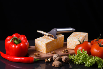 young woman slicing cheese in a gray apron