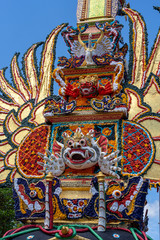 Naklejka premium Bade cremation tower with traditional balinese sculptures of demons and flowers on central street in Ubud, Island Bali, Indonesia . Prepared for an upcoming cremation ceremony