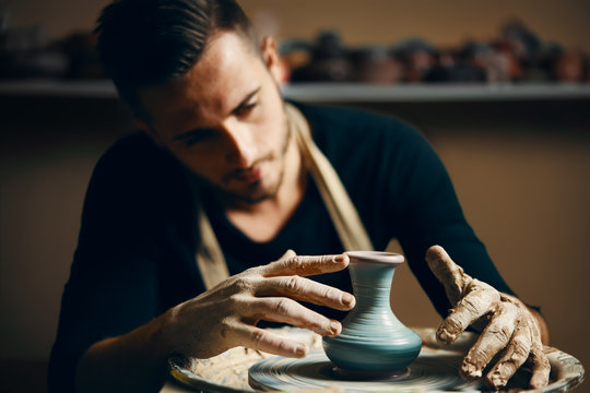 Potter modeling ceramic pot from clay on a potter's wheel