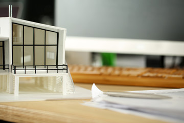 Modern building model standing at designer workplace
