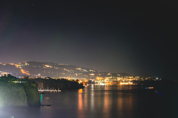 Fototapeta na wymiar Night scene of Sorrento, the pier with lots of yachts, a corner of the cityscape on a summer night, Amalfi coast, Italy