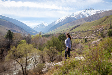 Fototapeta na wymiar Young girl on the background of spring mountains. Beautiful mountain gorge. Nature and adventure.