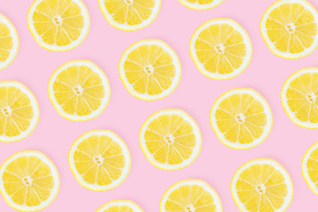 Bright rich background made of sliced lemons on pink. Design, visual art, minimalism, top view, flat lay. 