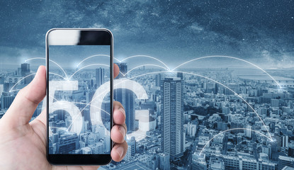 Hand using mobile smart phone, and wireless network connection technology in the city, with 5g...
