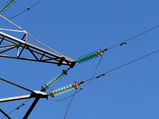 High-voltage power poles against the blue sky. Insulators power lines close-up. Electricity pylons.