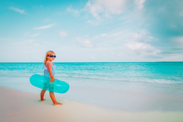 Fototapeta na wymiar cute little girl with inflatable life ring go swim at beach