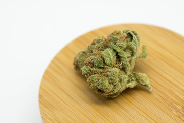 single marijuana bud isolated on wood