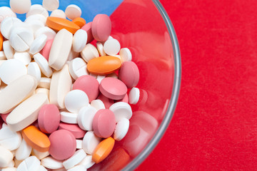 Multicolored pills on blue and red background. Medical concept. Texture.